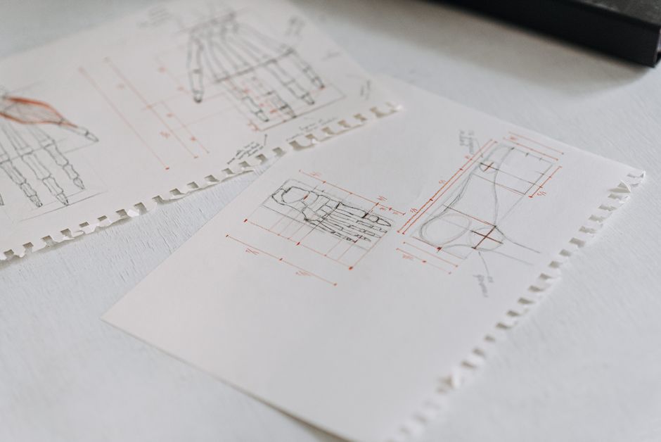Close-up of detailed technical drawings on neatly arranged white paper sheets, highlighting design concepts.